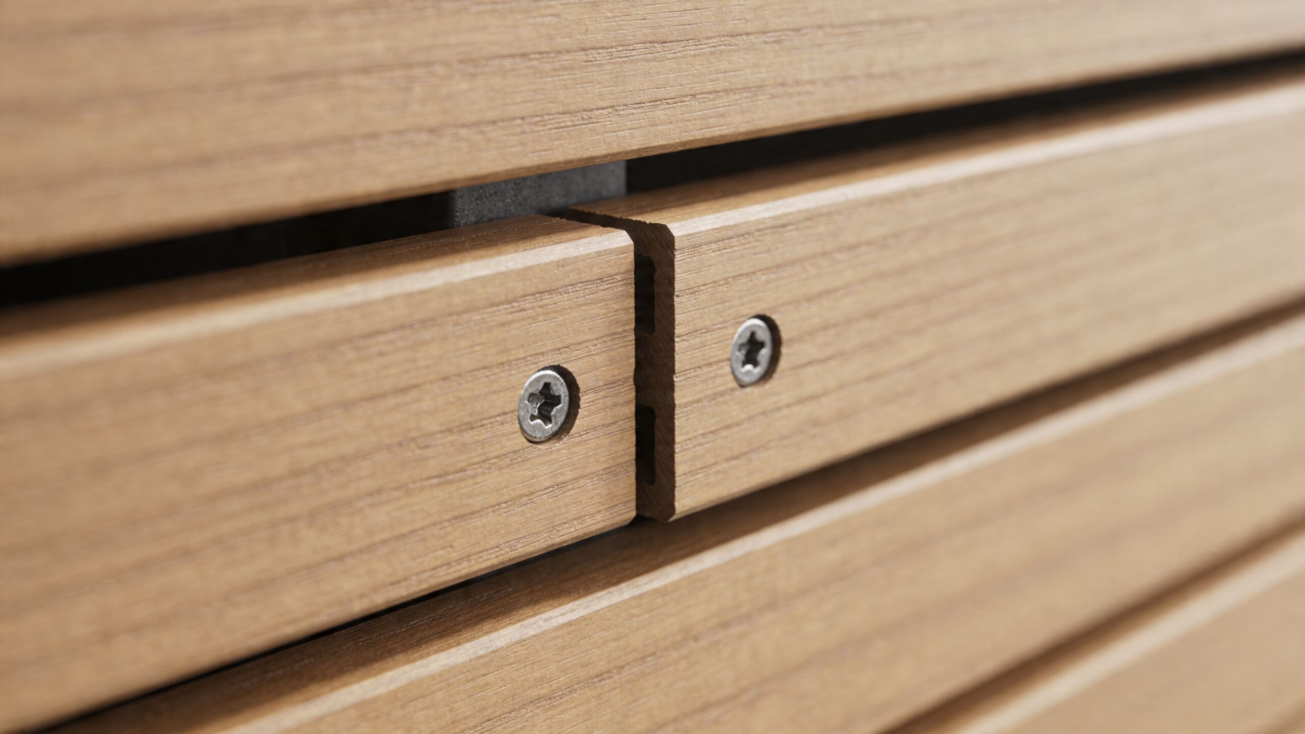 Nærbillede af superwood beklædning monteret med synlige skruer på en træfacade med et flot og moderne udtryk.